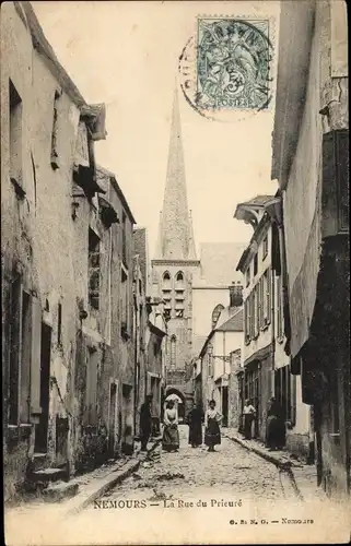 Ak Nemours Seine et Marne, La Rue du Prieuré, clocher, gens