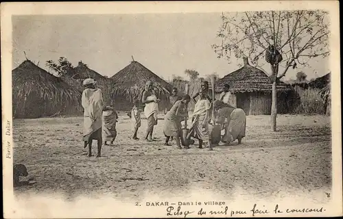 Ak Dakar Senegal, Dans le village, Dorfszene, Frauen stampfen Getreide