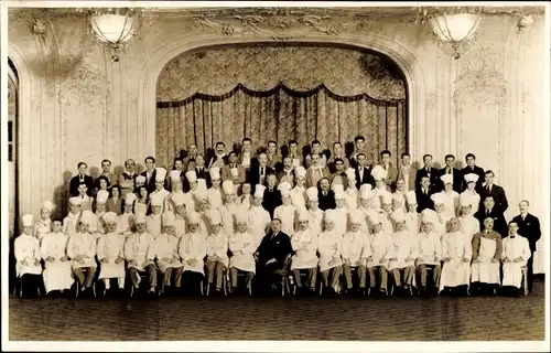 Foto Ak Gruppenfoto von Köchen und Kellnern vor einer Bühne, Restaurant