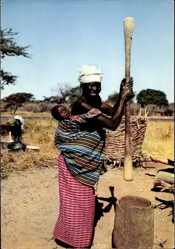 Ak Afrika, Mutter mit Baby bei der Arbeit im Dorf, Pileuse au village
