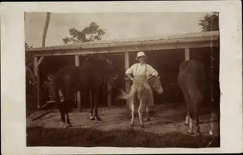 Foto Ak Guadeloupe, Kolonialist sitzt verkehrt herum auf Esel