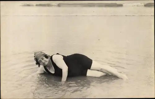 Ak Frau liegt am Strand im Wasser