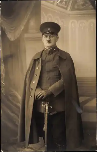 Foto Ak Deutscher Offizier im Kaiserreich, Portrait, Säbel, Feldmantel, Schirmmütze