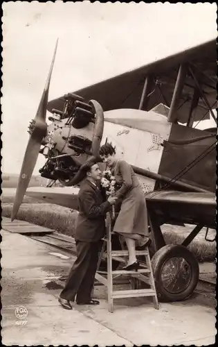 Ak Französisches Nieuport Doppeldecker Flugzeug, Frau auf Leiter, Blumenstrauß