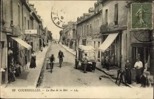 Ak Courseulles sur Mer Calvados, La Rue de la Mer, cyclistes