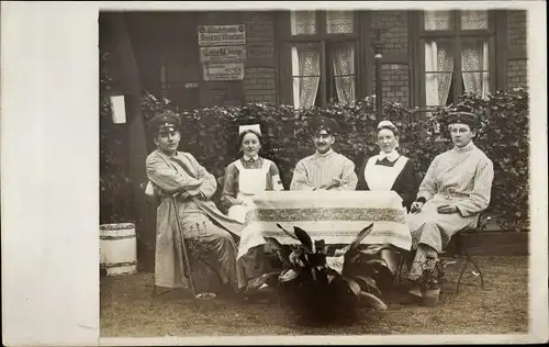 Foto Ak Lazarett, Deutsche Soldaten und Krankenschwestern am Gartentisch