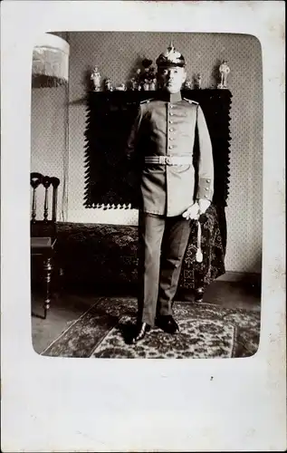 Foto Ak Deutscher Soldat, Standportrait in einem Wohnzimmer, Pickelhaube