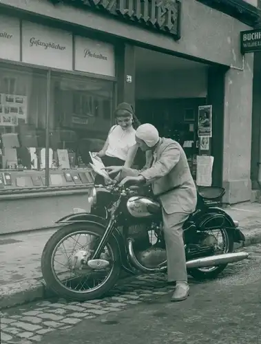 Foto NSU Motorrad, Buchhandlung, Frau zeigt Motorradfahrer ein Buch
