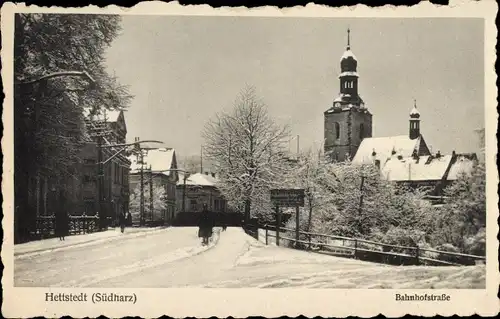 Ak Hettstedt Südharz, Bahnhofstraße im Schnee, Kirche