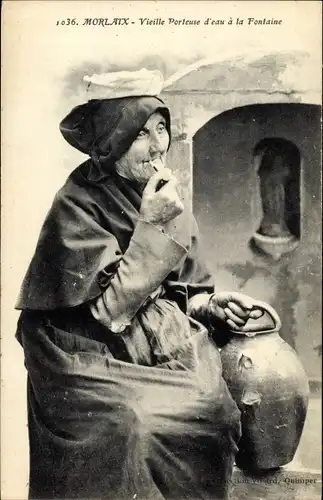 Ak Morlaix Finistère, Vieille Porteuse d'eau a la Fontaine, rauchende Frau in bretonischer Tracht