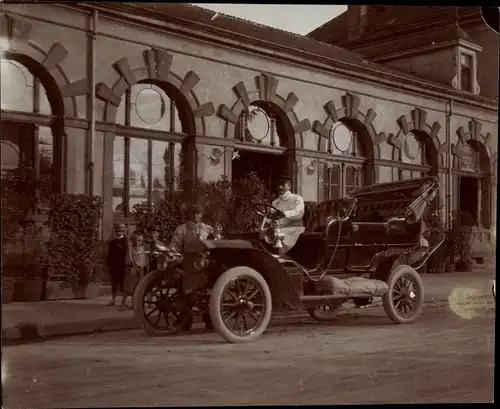 Foto Ak Mann in einem Automobil mit offenem Verdeck vor einem Gebäude