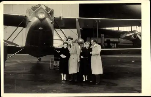 Foto Ak Männer und Frauen vor einem Kleinflugzeug, Doppeldecker