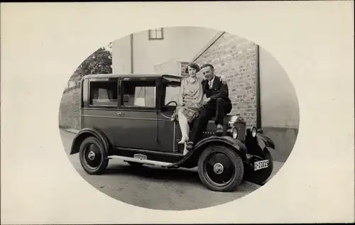 Foto Ak Mann und Frau auf der Kühlerhaube von einem Automobil