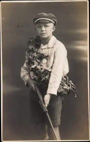 Foto Ak Junge mit Gewehr, Siegeskranz, Medaille, Portrait