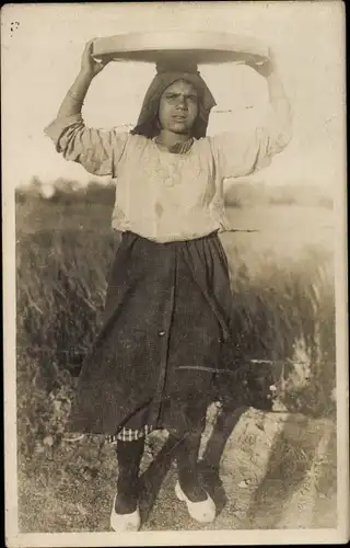 Foto Ak Standportrait einer Frau ein Gefäß auf dem Kopf tragend