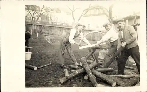 Foto Ak Drei Männer zersägen Holz