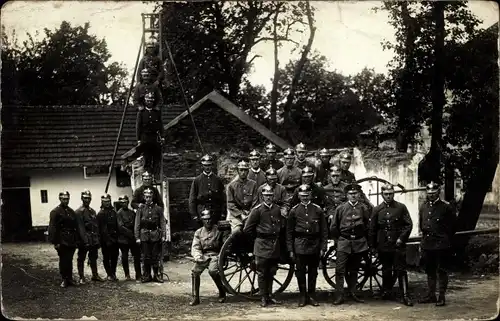 Foto Ak Feuerwehrleute vor Wasserpumpe, Gruppenaufnahme