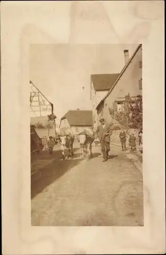 Foto Ak Mann mit Rinderkarren in einem Ort