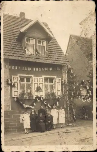 Foto Ak Malschenberg Rauenberg Rhein-Neckar-Kreis, Familie vor geschmücktem Wohnhaus