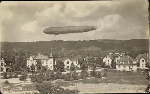 Foto Ak Zeppelin über einer Ortschaft, Luftschiff