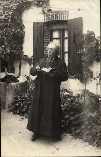 Foto Ak Ein Geistlicher mit Gebetbuch, Haus, Fenster
