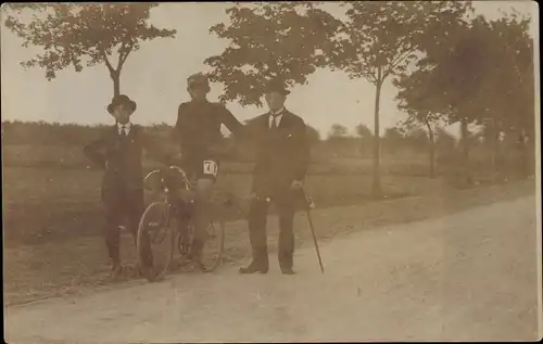 Foto Ak Radrennsport, Fahrer auf dem Rad, Männer am Straßenrand