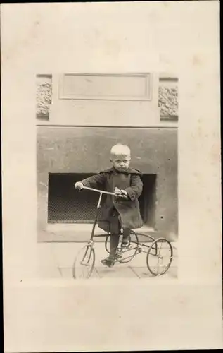 Foto Ak Kleiner Junge auf einem Dreirad