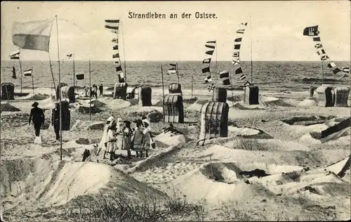 Ak Strandleben an der Ostsee, Strandkörbe, Strandburgen, Fahnen, Blick aufs Meer