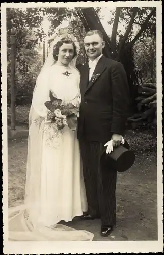 Foto Ak Frau im Brautkleid, Mann im Anzug, Hochzeitspaar