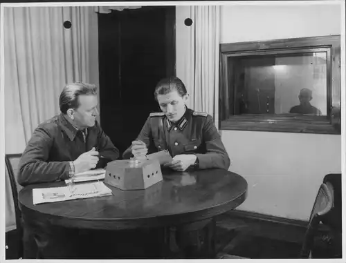 Foto Mann in Uniform und Arbeiter an einem Tisch, DDR, Volkspolizei