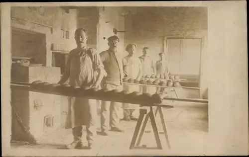 Foto Ak Bäcker mit Broten vor den Öfen, Bäckerei