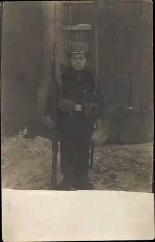 Foto Ak Junge in Uniform mit Gewehr und Marschgepäck, Pickelhaube