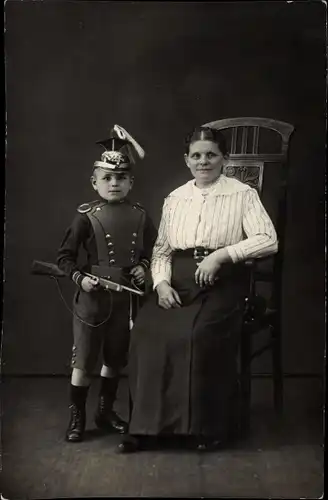 Foto Ak Junge in Ulanenuniform, sitzende Frau, Portrait