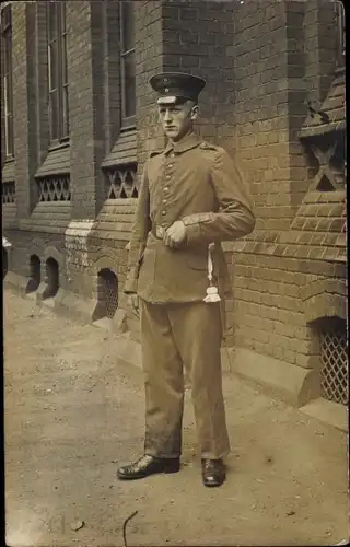 Foto Ak Deutscher Soldat in Uniform, Standportrait, Schirmmütze, Quaste
