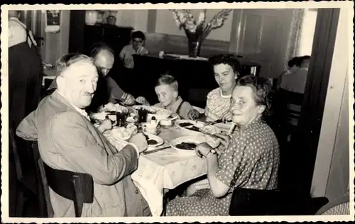 Foto Ak Personen an einem Tisch im Restaurant