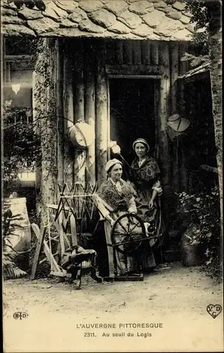 Ak Auvergne, Au seuil du Logis, Frauen in Trachten, Spinnrad