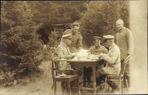 Foto Ak Deutsche Soldaten in Uniform am Esstisch im Garten, Suppenterrine
