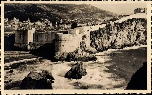 Ak Dubrovnik Kroatien, Blick auf die Stadt und Felsen vom Meer aus