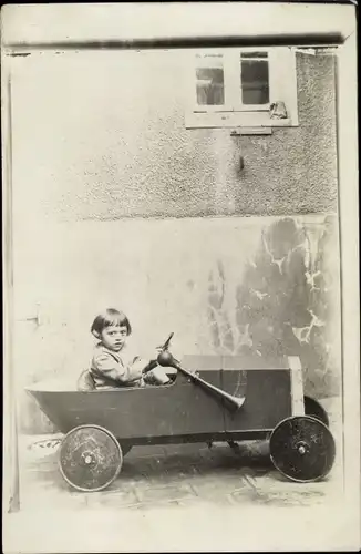 Foto Ak Kind in einem Spielzeugauto, Seifenkiste
