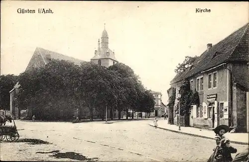 Ak Güsten im Salzlandkreis, Straßenpartie mit Kirche, Mädchen mit Hut, Geschäfte