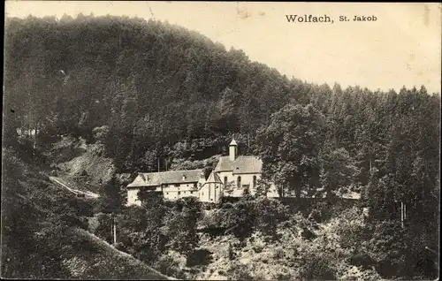 Ak Wolfach im Schwarzwald, Waldpartie mit Kirche St. Jakob