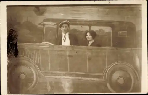 Foto Ak Mann und Frau in einem gemalten Automobil