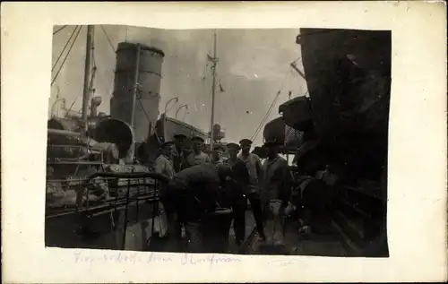 Foto Ak Seeleute vor einem Schiff im Hafen