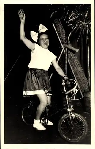 Foto Ak Frau mit Haarschleife und kurzem Rock auf Mini Fahrrad
