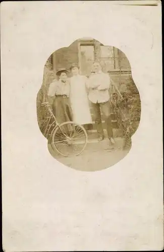 Foto Ak Zwei Frauen und ein Mann mit Fahrrad