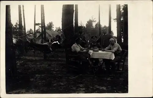 Foto Ak Deutsche Soldaten in Uniform, Lager im Wald, Kartenspiel am Tisch, Hängematte, Hund