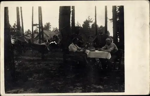 Foto Ak Deutsche Soldaten in Uniform, Lager im Wald, Kartenspiel am Tisch, Hängematte, Hund