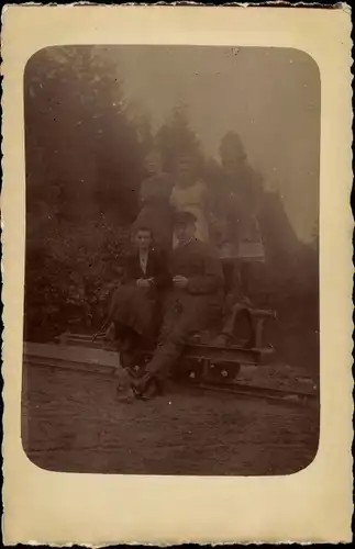 Foto Ak Familienbild, Ehepaar auf einer Draisine sitzend, Kinder