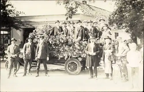 Foto Ak Männer in Anzügen mit einem geschmückten Festwagen