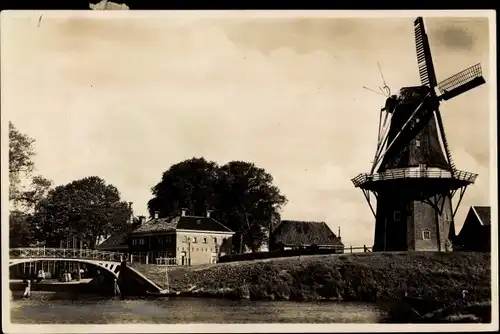 Foto Ak Dakkum Friesland, Windmühle, Brücke, Häuser